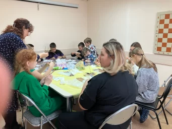 мастер помогает участникам в процессе плетения