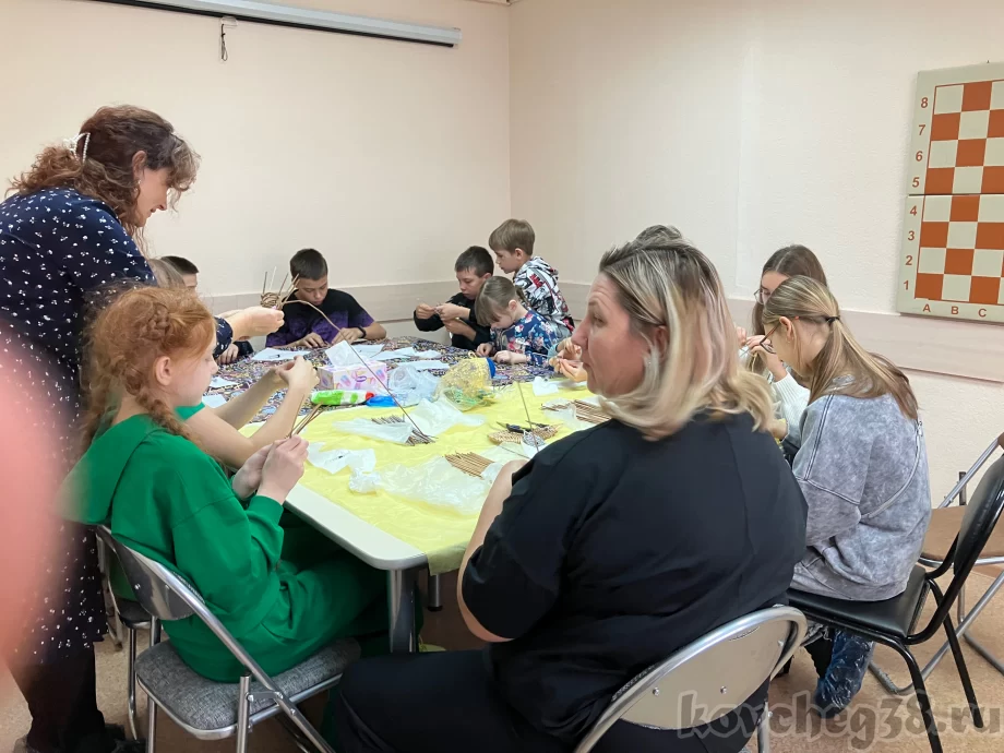 мастер помогает участникам в процессе плетения